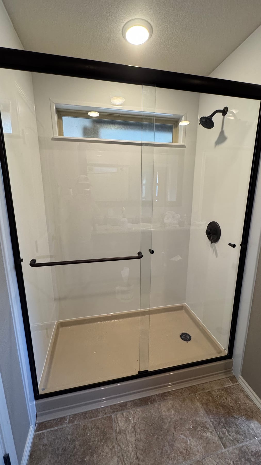 Modern white shower with glass doors and matte-black fixtures